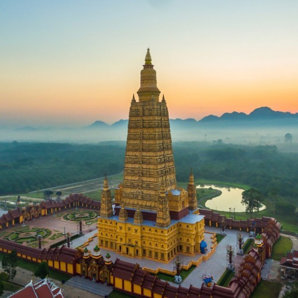 Der goldene Chedi des Wat Maha That Wachira Mongkol bei Sonnenaufgang aus der Luft